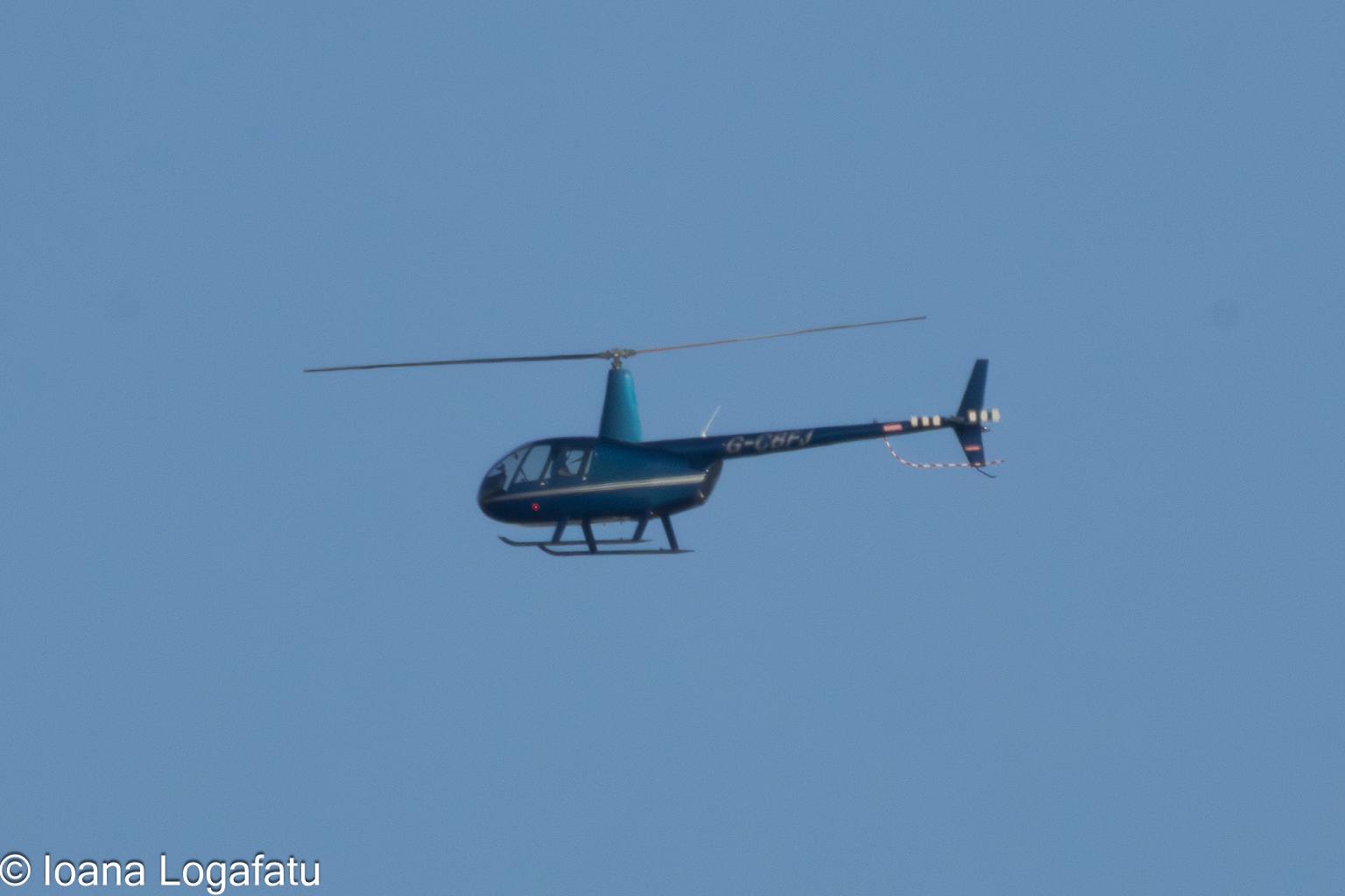 Helicopter soaring through the clear blue sky
